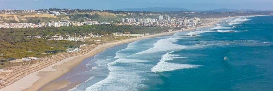Aerial view of Costa da Caparica with long sandy beaches and rolling waves