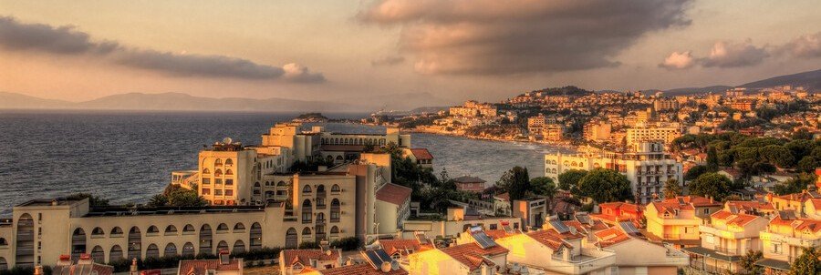 Sunset over Kusadasi coastline with buildings and ocean view