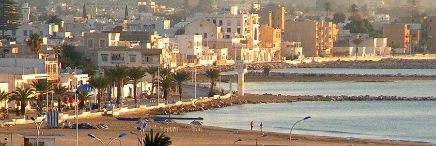Sandy beach and waterfront promenade near La Goulette Port in Tunisia.