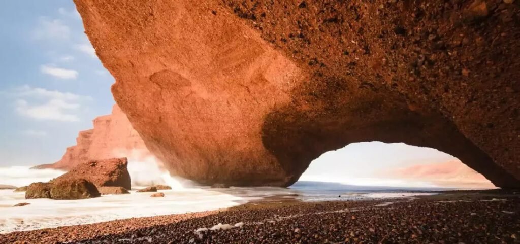 A massive red sandstone arch at Legzira Beach near Agadir Port in Morocco's Souss-Massa region.
