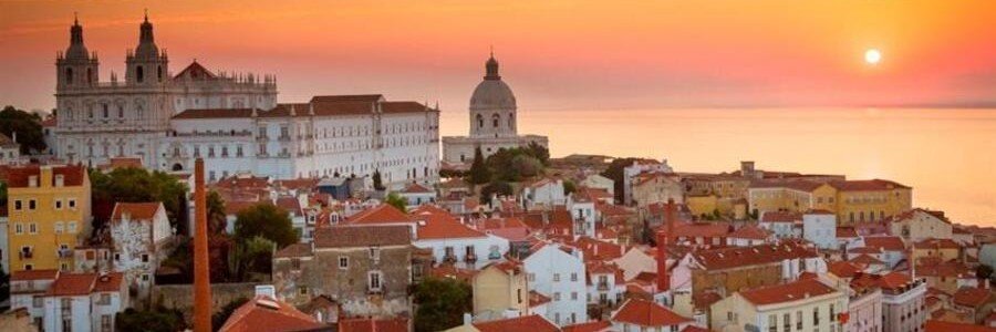 Lisbon skyline at sunset with orange sky and historic buildings