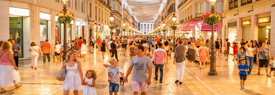 Málaga shopping street with lively crowds, boutiques, and evening lights