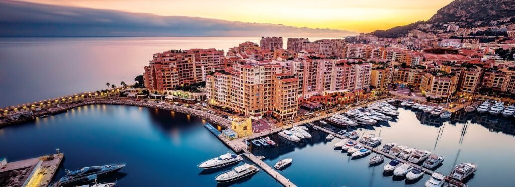 Monaco Port and Monte Carlo harbor at sunset with luxury yachts and waterfront buildings