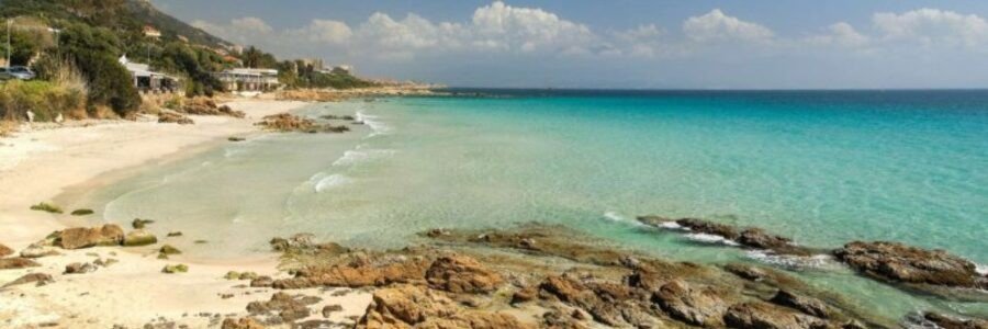 Plage de Barbicaja Ajaccio Corsica with clear turquoise water, rocks, and sandy shoreline