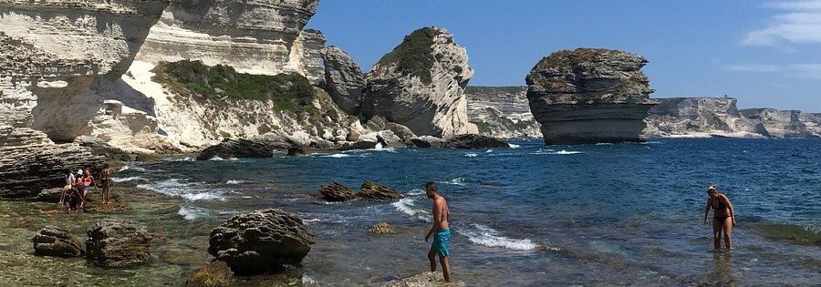Plage de Sutta Rocca Bonifacio Corsica with limestone cliffs, clear water, and rocky shoreline
