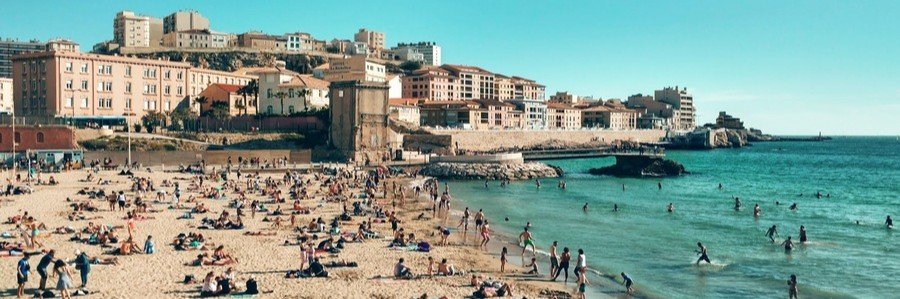 Plage des Catalans beach in Marseille with people relaxing on the sand and swimming in the Mediterranean