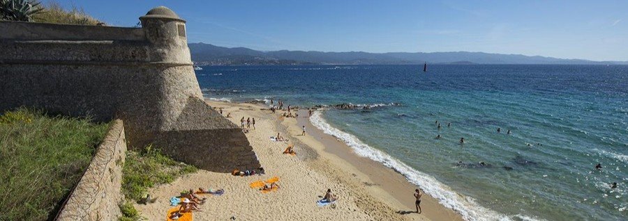Plage Saint François Ajaccio beach with golden sand and clear blue water near historic walls
