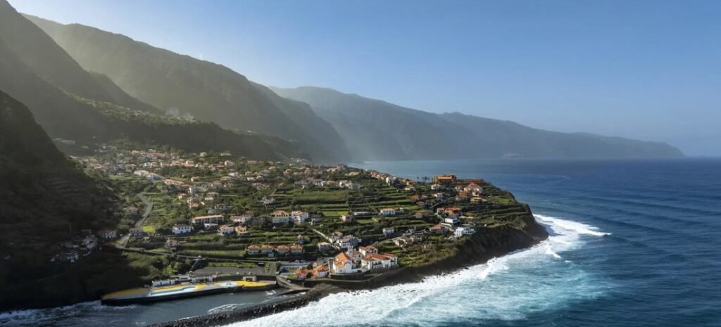 Panoramic view of the lush volcanic coastline and traditional white houses near Ponta Delgada and Azores shore excursion routes.