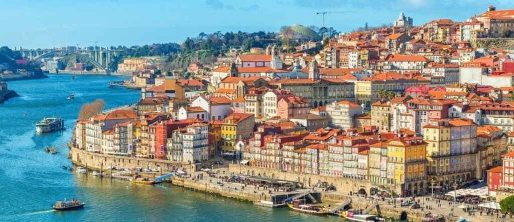 Panoramic view of the Porto Port riverfront showing the colorful buildings of the historic Ribeira District along the Douro River.