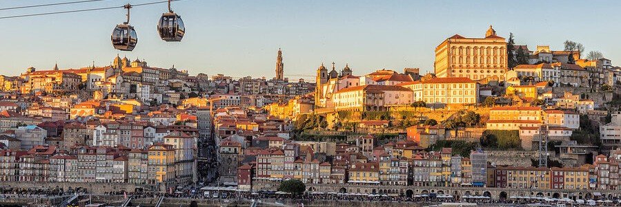 Porto skyline at sunset with cable cars and historic buildings overlooking Douro River