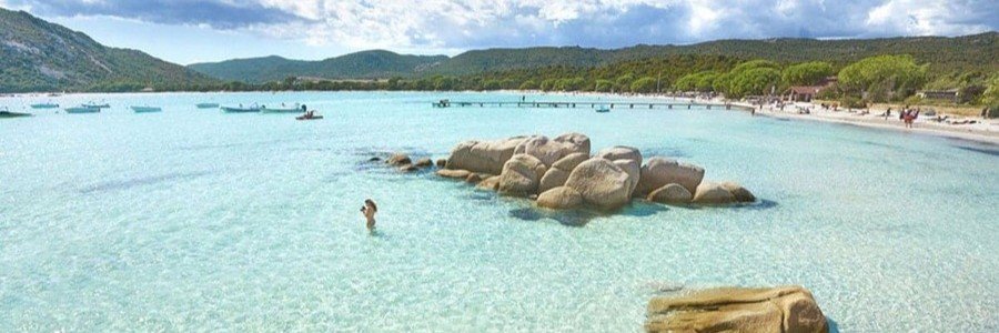 Porto Vecchio Corsica beach with crystal clear turquoise water, white sand, and granite rocks