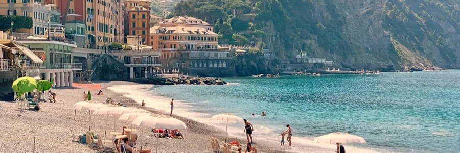 Beach near Portofino with turquoise water and coastal village buildings