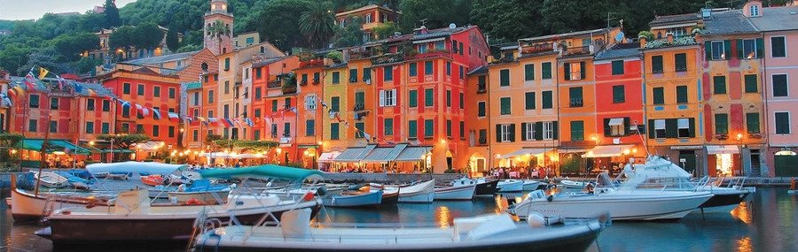 Colorful harbor view as boats arrive at Portofino Port with pastel buildings and yachts