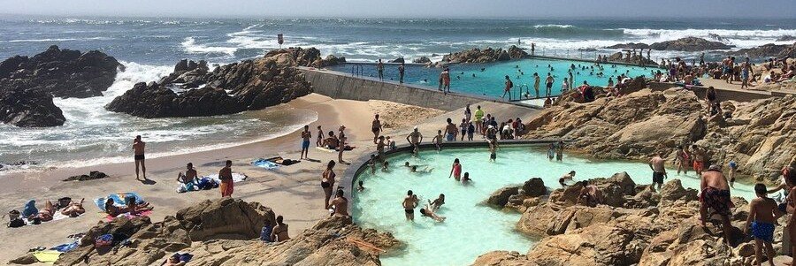 tidal pools at Praia de Leça da Palmeira with people swimming along rocky coast