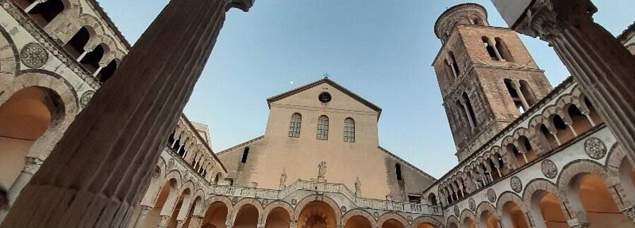 Romanesque arches and a quiet courtyard garden inside the historic Salerno Cathedral.