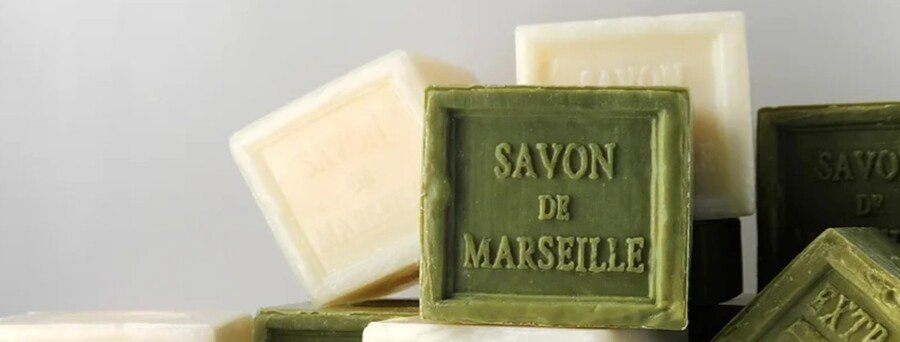 Savon de Marseille traditional olive oil soap bars stacked with embossed lettering on a clean background