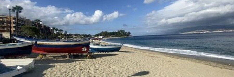 Spiaggia del Ringo beach in Messina with boats and sandy shoreline