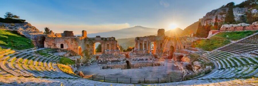 Ancient theatre in Taormina with Mount Etna and coastal views at sunset