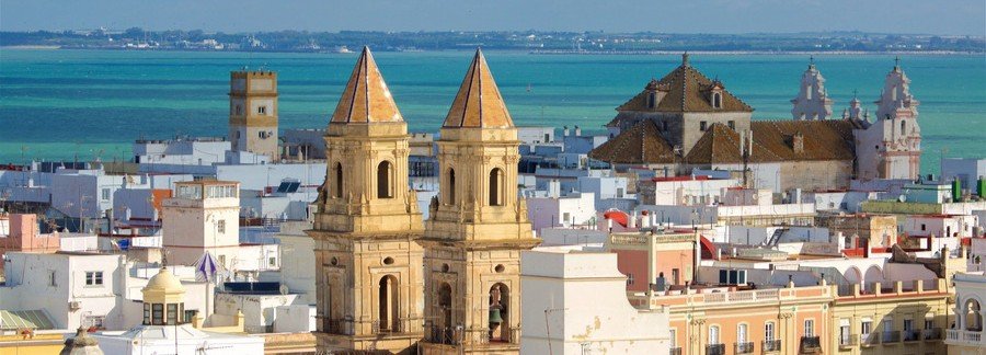 View from Torre Tavira in Cádiz overlooking rooftops, towers, and the coastline