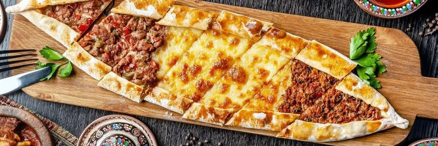 Turkish pide flatbread with meat and cheese on wooden board