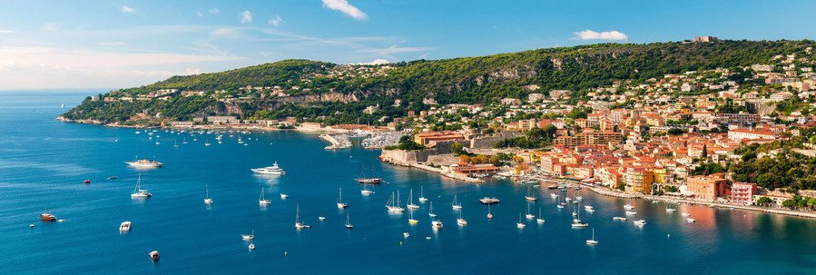 Villefranche-sur-Mer bay with boats, colorful waterfront buildings, and hillside views along the French Riviera