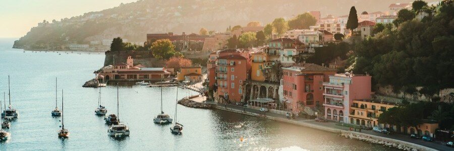 Villefranche-sur-Mer coastal village with colorful buildings and boats in the harbor at sunset on the French Riviera