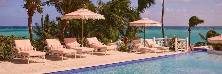 Oceanfront pool with pink umbrellas and tropical views at Coral Sands Inn in Flagler Beach, Florida.