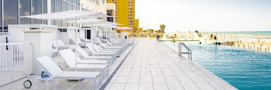 Beachfront pool deck at Daytona Grande Oceanfront Resort overlooking Daytona Beach and the Atlantic Ocean.