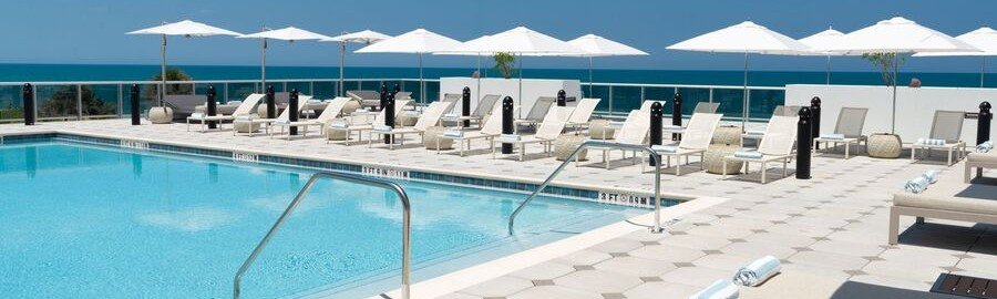 Oceanfront swimming pool with lounge chairs and umbrellas at Element by Marriott Melbourne Oceanfront.