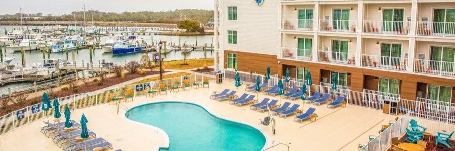 Compass Hotel pool overlooking the marina in Flagler & Palm Coast, Florida with waterfront views and lounge chairs.