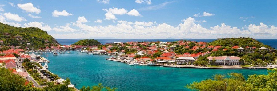 Panoramic view of Gustavia Harbor with turquoise water and red-roofed buildings in St. Barts