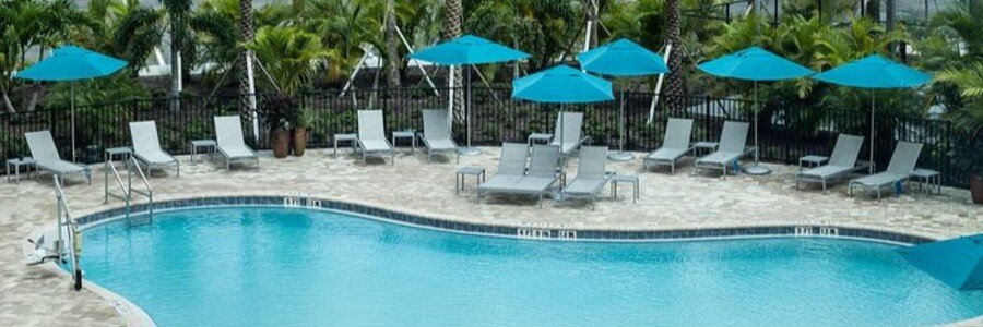 Outdoor swimming pool and lounge area at Hampton Inn & Suites Cape Canaveral Cruise Port.