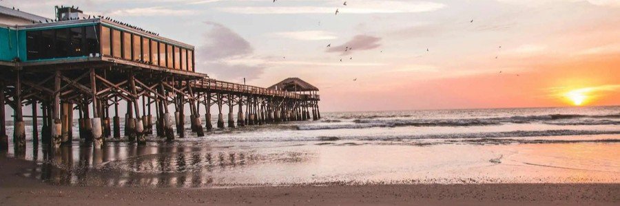 Pier Sunset Near Indian Harbour Beach | Beach Travel Destinations Pier extending into the Atlantic Ocean during a colorful sunset near Indian Harbour Beach.