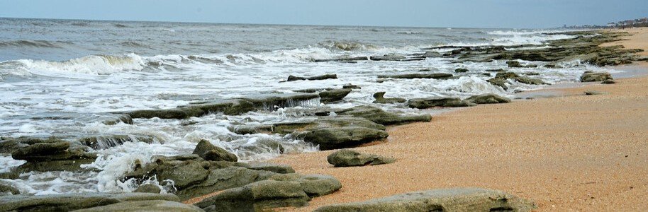 Coquina rock formations and cinnamon-colored sand at Jungle Hut Road Beach in Palm Coast, Florida.