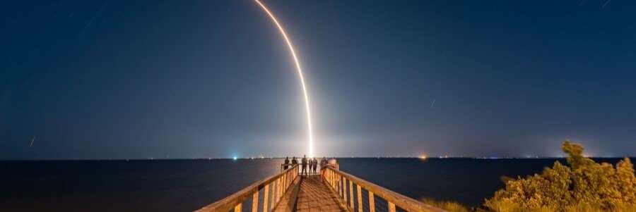 Visitors watch a rocket launch from a pier near Satellite Beach along Florida's Space Coast.