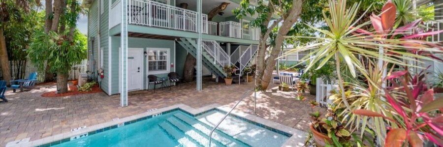 Tropical courtyard pool surrounded by palm trees at Seaglass Inn near Indian Harbour Beach.