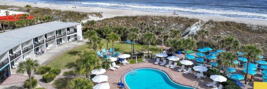 Seahorse Oceanfront Inn in Neptune Beach, Florida, featuring a beachfront pool, palm trees, ocean views, and direct access to the sandy Atlantic coastline.