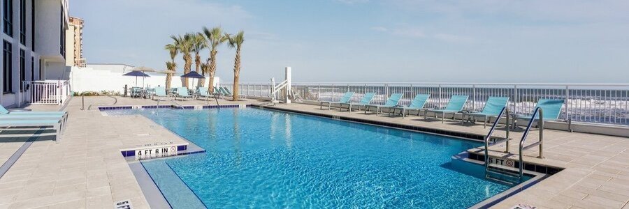 Oceanfront swimming pool and lounge chairs at Traders Inn Beach Club in Flagler Beach, Florida.