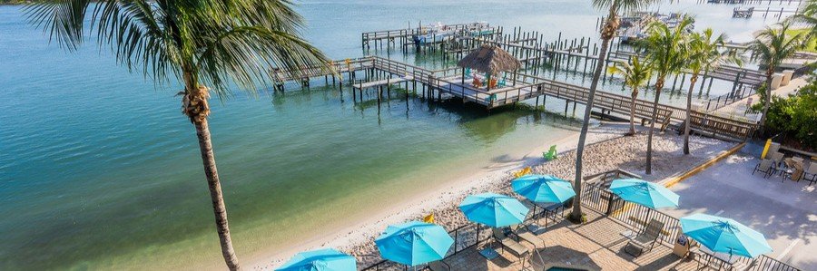 Waterfront resort with beach, palm trees, and private docks on Hutchinson Island, Florida.