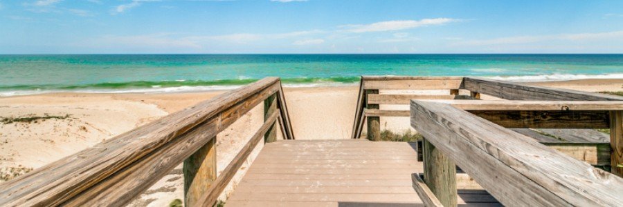 Wooden boardwalk leading to the sandy beach in Indialantic, Florida.