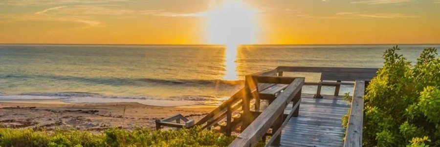 Sunset over the Atlantic Ocean from a beach boardwalk in Indian River Shores, Florida.
