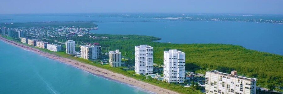 Aerial view of Jensen Beach with oceanfront condos, sandy beach, and the Indian River Lagoon in Florida.