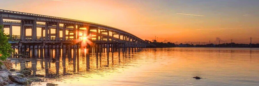 Merritt Island Causeway Sunset Views Sunset shining beneath the Merritt Island Causeway bridge over the Indian River Lagoon.