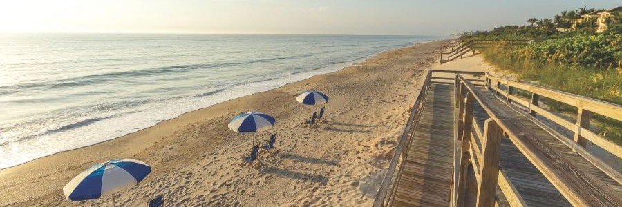 Quiet Orchid Florida beach with umbrellas and an oceanfront boardwalk
