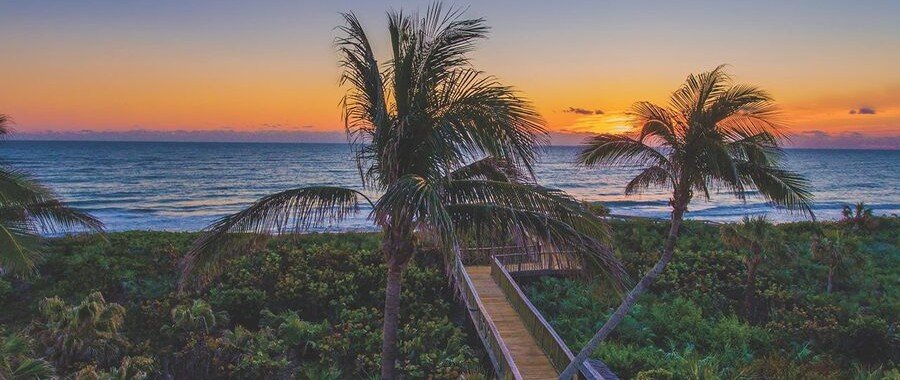 Sunset over the Atlantic Ocean viewed from a beach boardwalk in Orchid, Florida.