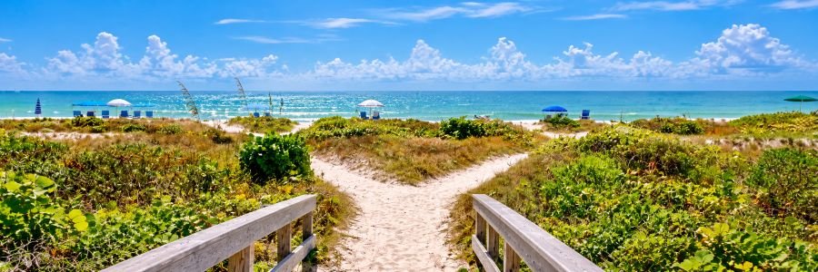 Sandy beach path leading through coastal dunes to the turquoise Gulf waters near Fort Myers, Florida