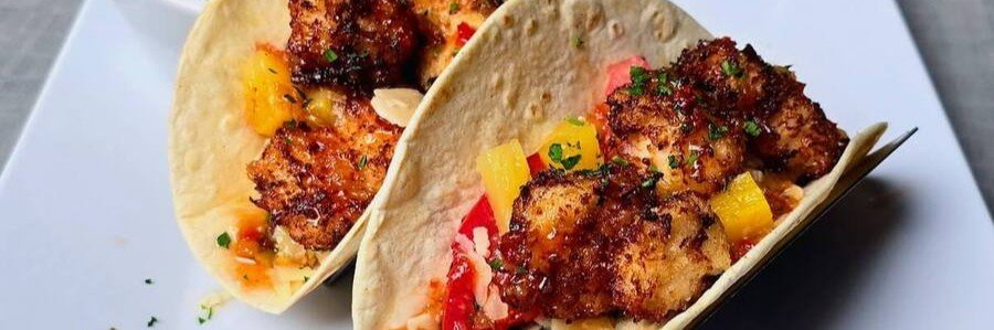 Blackened Fish Tacos with Fruit Salsa | Beach Travel Destinations Two blackened fish tacos with peppers, fruit salsa, herbs, and creamy sauce
