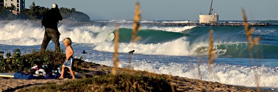 Surfers riding waves at Stuart Rocks, a popular surf spot in Stuart, Florida.