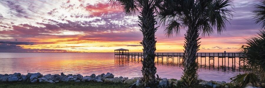 Sunset over the Indian River Lagoon with a fishing pier in Titusville, Florida.