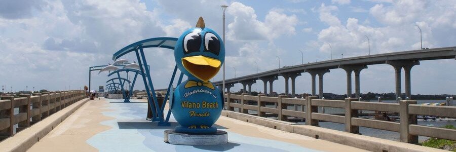 Vilano Beach Pier and Bluebird of Happiness statue near St. Augustine, Florida.